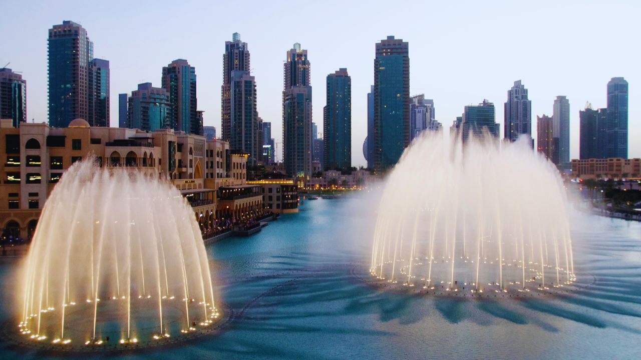 Dubai Fountain performing a spectacular water and light show with city skyline backdrop.