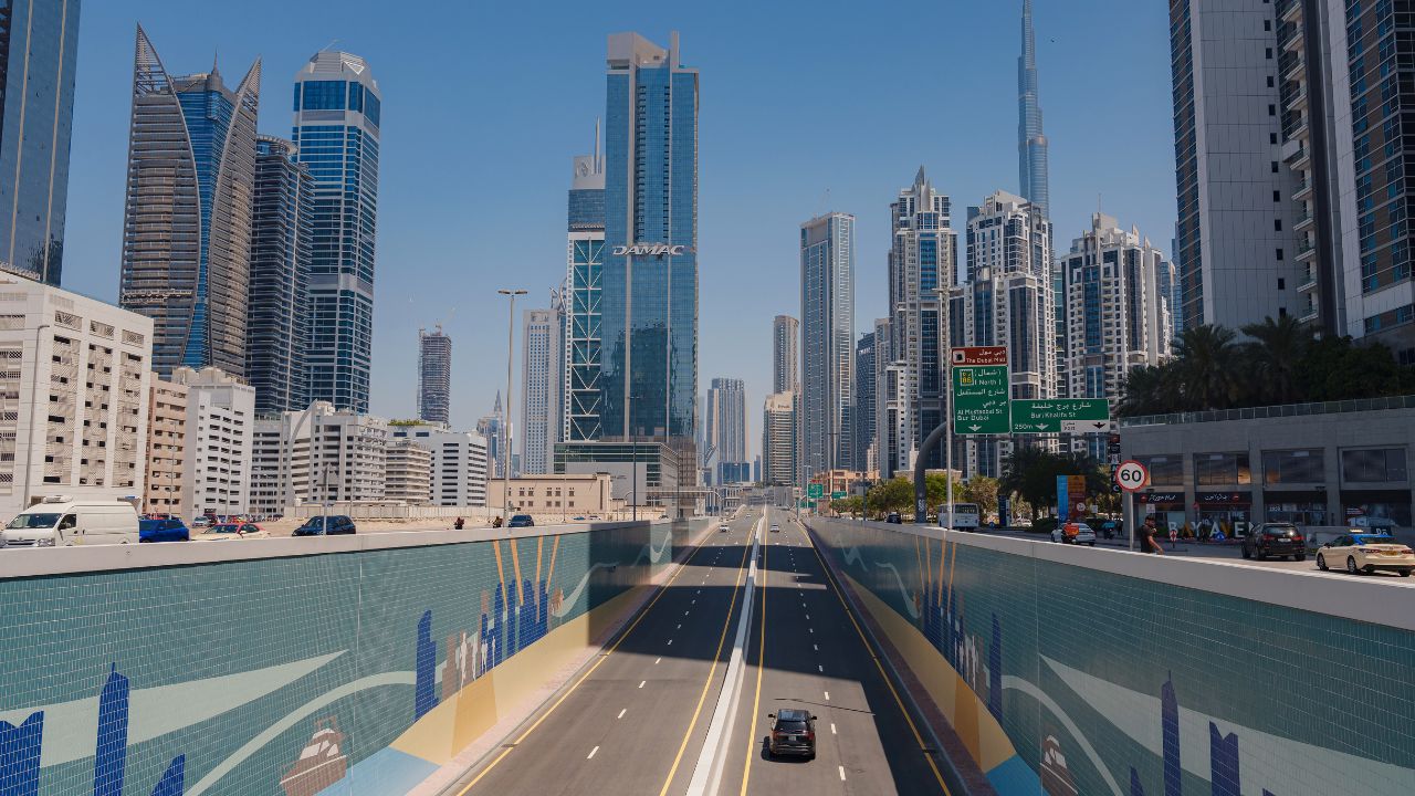 Dubai cityscape with tall buildings and clear blue sky.