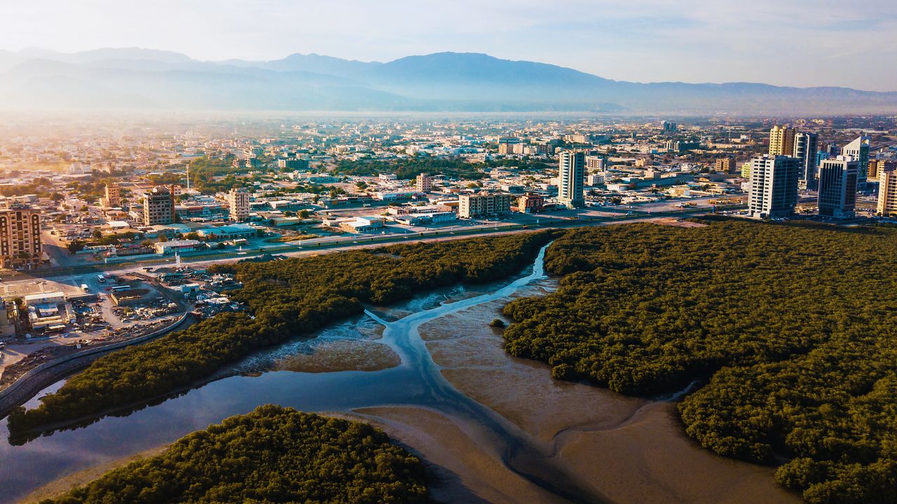 Aerial view of Ras Al Khaimah with mountains and river, perfect for summer road trips.