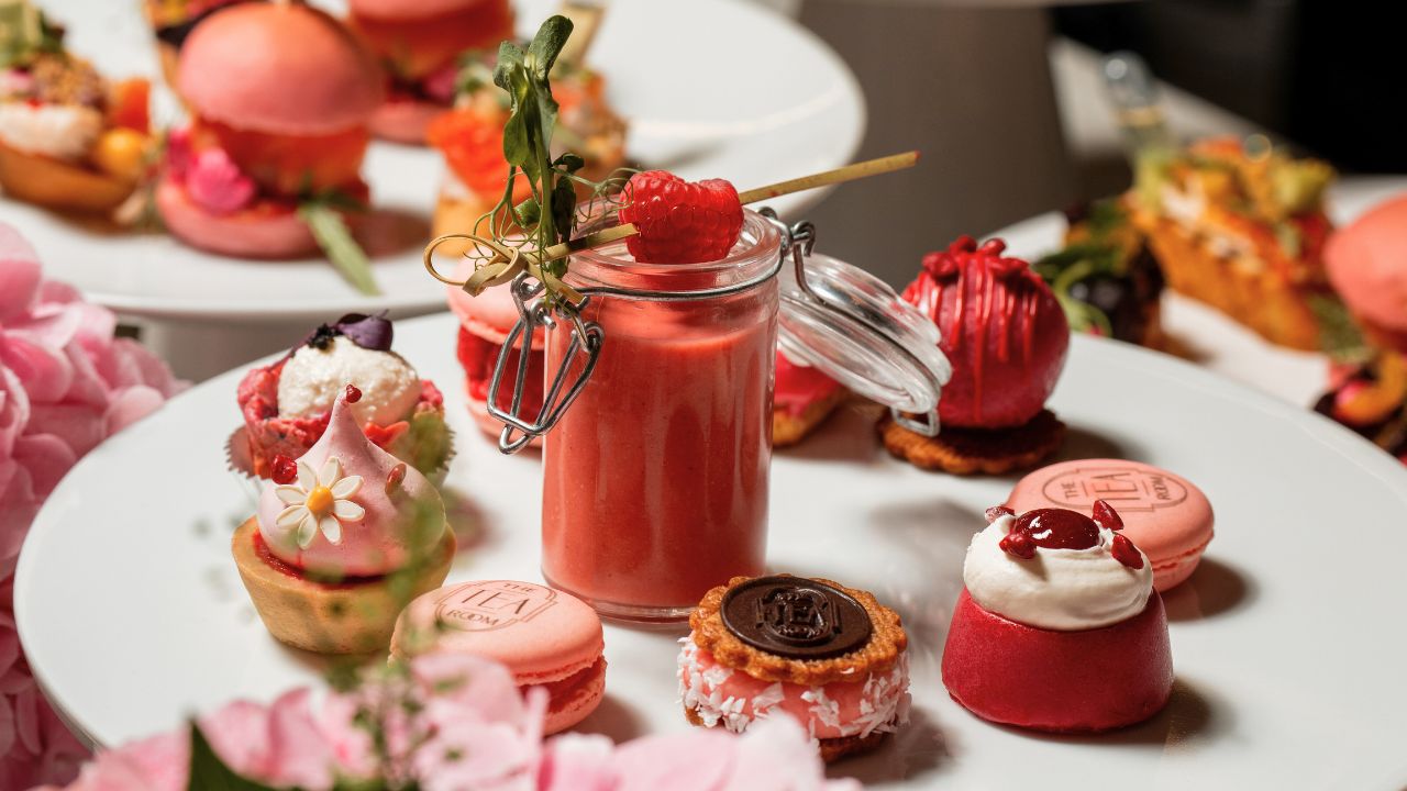 Assorted pastries and desserts including macarons, cupcakes, and a berry drink, perfect for indulgen.