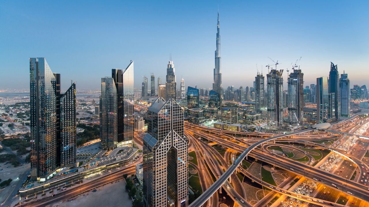 A vibrant cityscape with skyscrapers and highways near Dubai and Abu Dhabi.