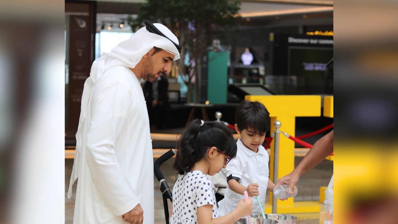 Father and children enjoying family activities at Dubai mall during half-term holiday.