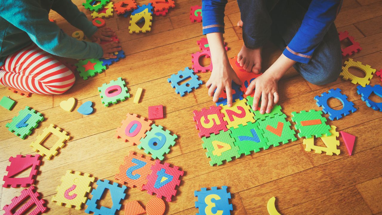 Children playing with colourful educational foam puzzles.