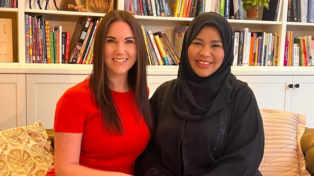 Diverse women sharing stories in a library setting.
