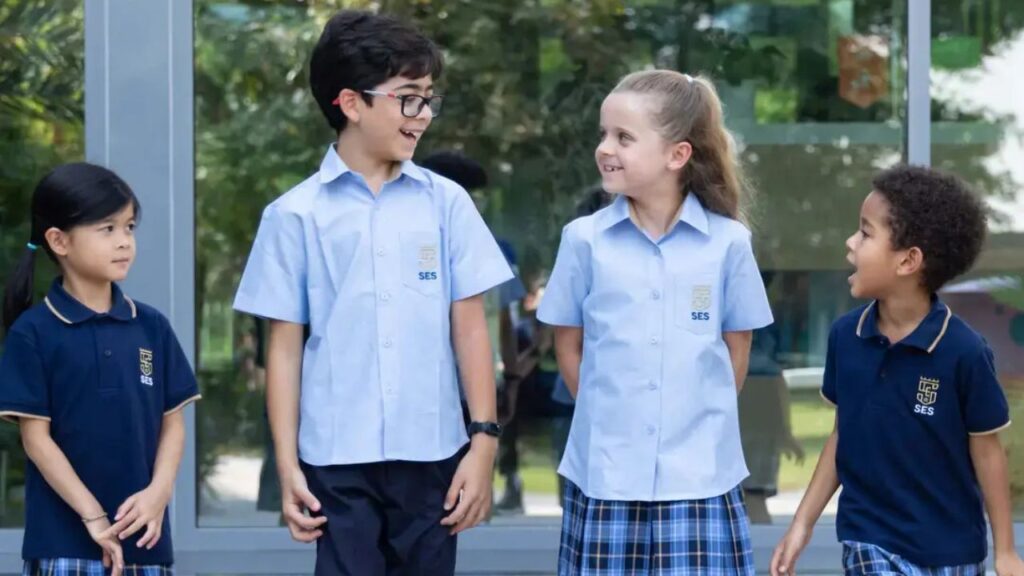 Group of diverse students smiling outdoors at Sharjah English School.