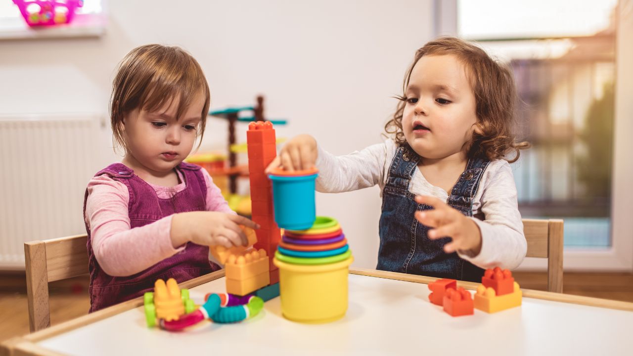Two young children playing with colourful toys at a Dubai nursery.