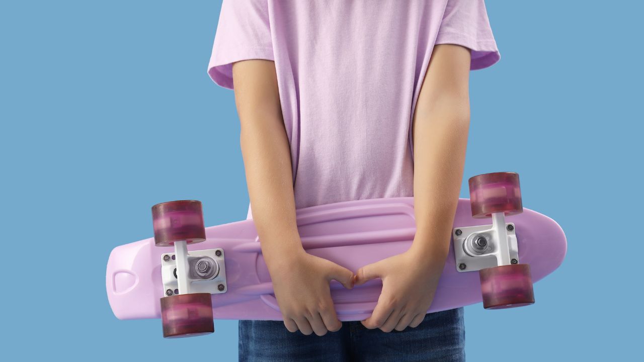 kid holding a penny board or skateboard