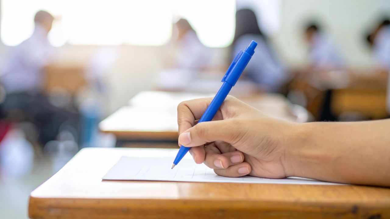 Exam paper being written in a classroom during online school exams.