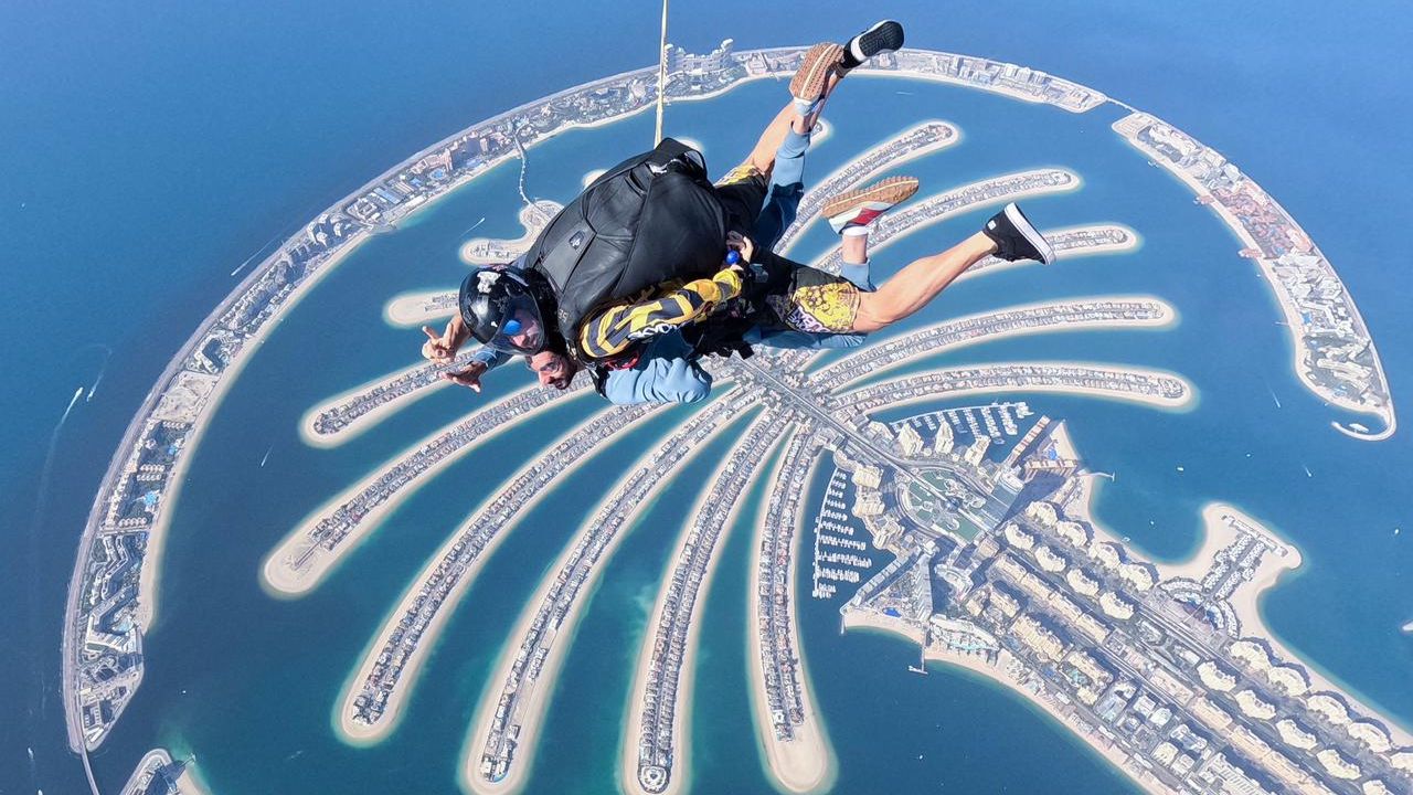 man skydiving in dubai with view of palm jumeirah