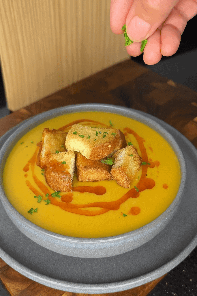 Creamy and comforting Turkish lentil soup served in a bowl, topped with paprika-mint butter and fresh parsley, inviting you to enjoy a warm, flavorful, and easy-to-make meal.