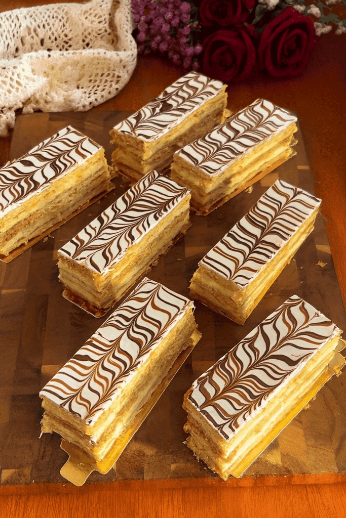 Classic Mille-feuille (1000 Layers) pastry with crisp golden puff pastry sheets and smooth vanilla cream, layered neatly and topped with powdered sugar.