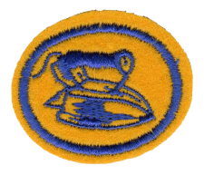 Runde Stickereiabzeichen mit Feuerwehrhelm und Eimer, orange und blau, symbolisiert Brandschutz und Feuerwehrdienst. Perfekt für Feuerwehruniformen und Auszeichnungen.