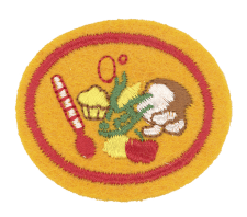 Küchenschürzen-Applikation mit Kuchen, Kochlöffel und Zutat, für Kinder oder Nähliebhaber, detailreiche Stickerei, auf oranger Aromasignalfarbe gestaltet, ideal für Hobby- oder Schulprojekte.