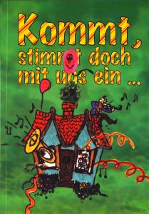 Bunt illustriertes Kinderbuch mit Haus, Musik, Ballon, Katze und Maus auf grünem Hintergrund.