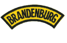 BILD: Nähte und Textilbrand auf einem Stoffpatch mit dem Schriftzug "BRANDENBURG" in Gelb und Schwarz.