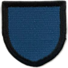 Blue fabric patch with black border for uniform or badge, close-up of embroidered textile item, used in workwear or accessories, available in central warehouse.