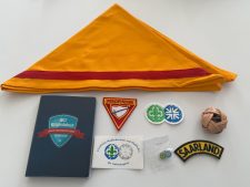 Flaggenstoff mit Scout-Abzeichen und Pfadfinderzubehör für Christliche Pfadfinder, Saarland, Advent-Verlag, Mitgliedsbuch, Buttons, Ball, Lernmaterialien, themenbezogene Accessoires, Pfadfinder-Logo.