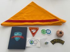 Farbenfrohes Zelt- und Pfadfinderzubehör mit Abzeichen, Mitgliedsbuch, Bällen und Bändern für die Pfadfinder-Ausbildung, ideal für das Zentrallager von Advent-Verlag.