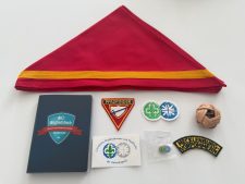 Roten Pfadfinderhalstuch mit gelbem Streifen, Pfadfinderabzeichen, Mitgliedsbuch, Anstecknadeln, Aufnäher "Mecklenburg Vorpommern", Wanderknotenschnur, und Pfadfinder-Sticker, alle ordnungsgemäß auf einem weißen Hintergrund für bestes SEO.