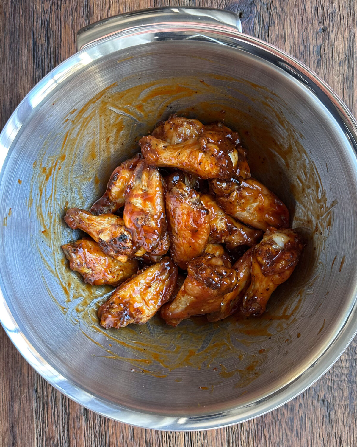 Chicken wings tossed in sauce for a baked sticky chicken wings recipe.