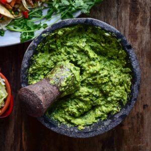 A large molcajete with freshly made grilled guacamole.