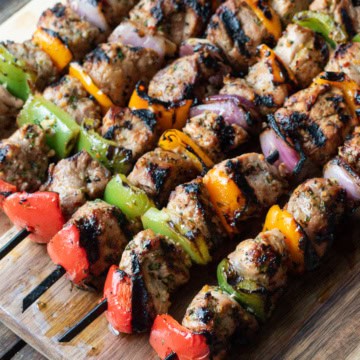 Rows of pork tenderloin and vegetable skewers.