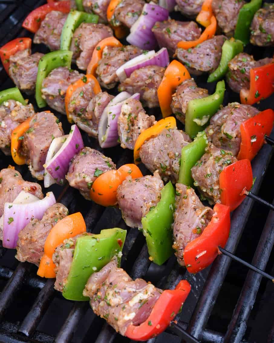 Six colourful, meat and veggie skewers on the grill.