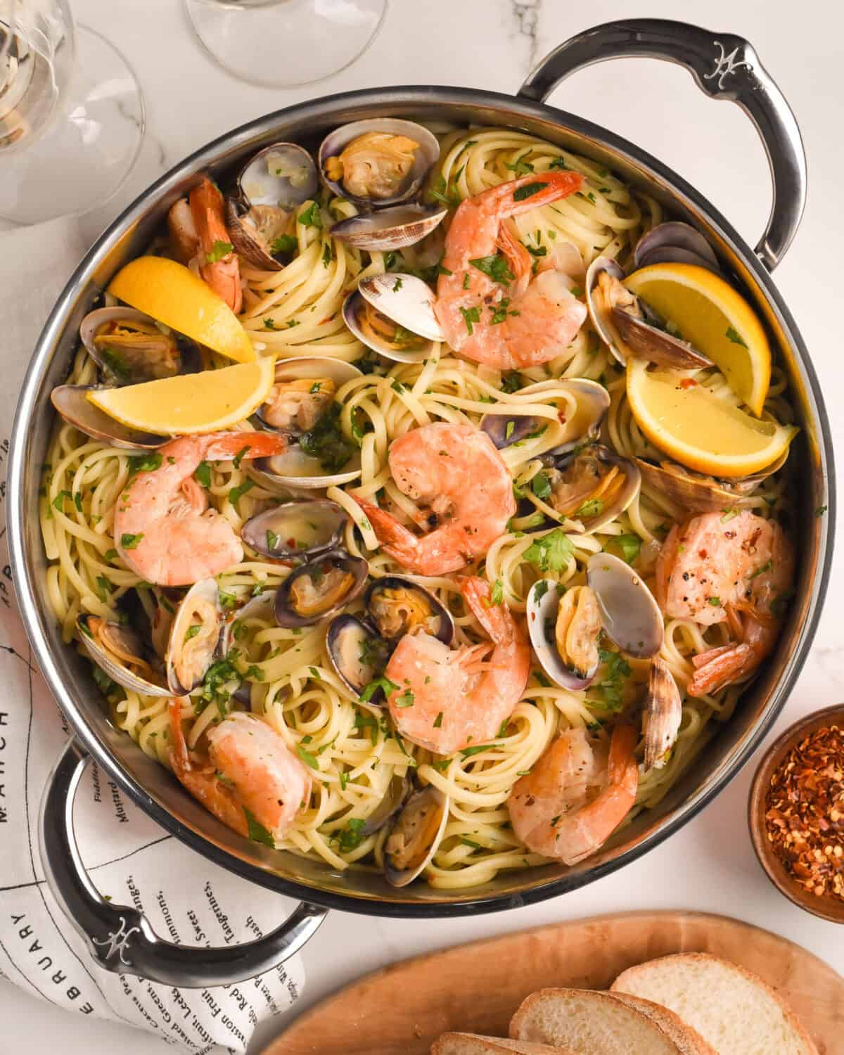 A top down image of a pot of Spicy Linguine with Clams and Colossal Shrimp.