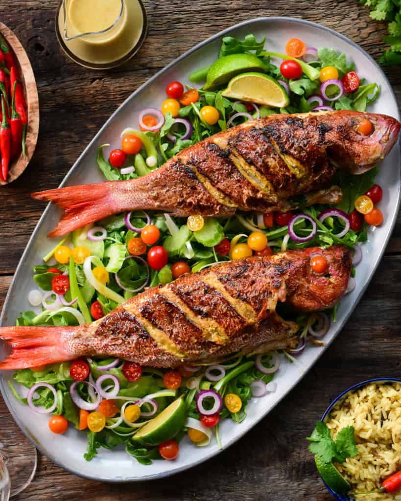 Tso Pan Fried Wild Vermilion Snapper fish with Green Curry. Served over a bed of arugula salad with tomatoes.