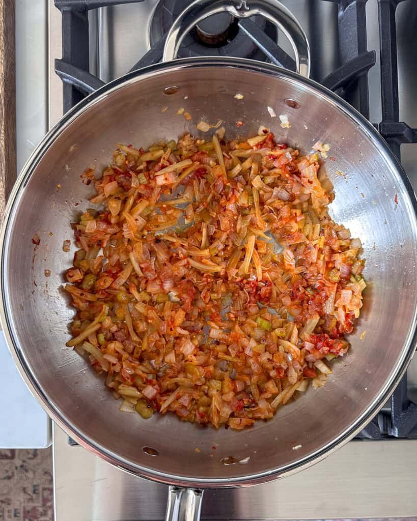 Add the tomato paste to the sautéed onions.
