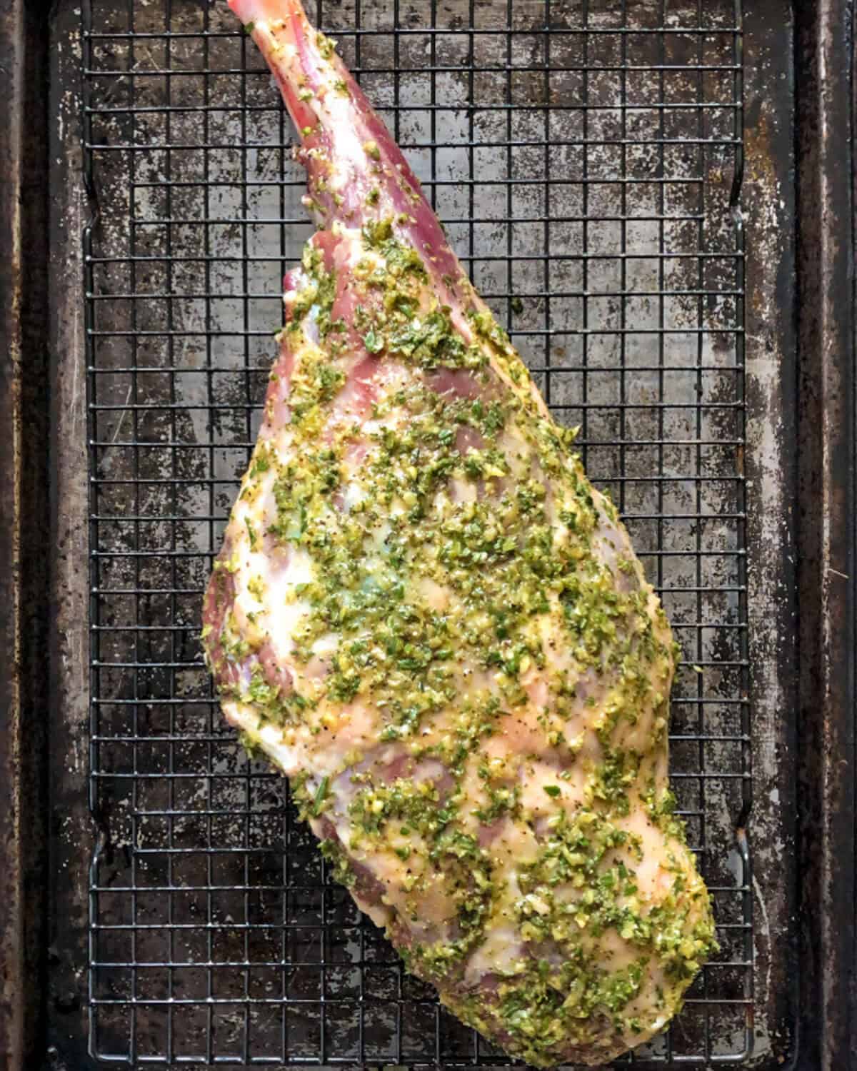 Place the lamb on the prepared rack/sheet pan, pat the lamb dry, then rub paste all over the lamb and let it stand at room temperature for 30 minutes.