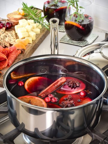 A simmering pot of winter mulled wine with fruit.