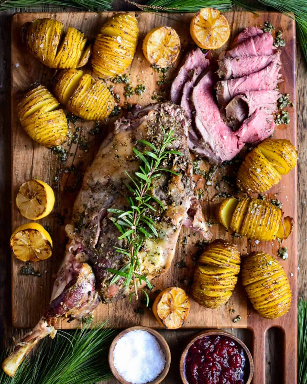 A sliced roasted leg of lamb with hasselback potatoes.