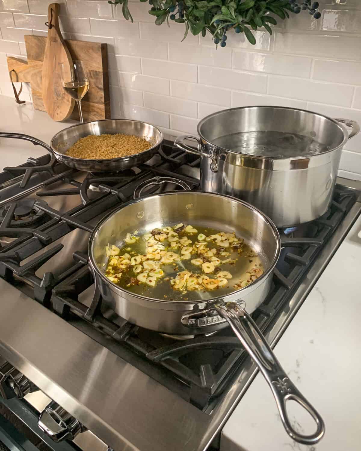 Add garlic, chilies and anchovies into hot oil and build the sauce for the Linguine alle Vongole.
