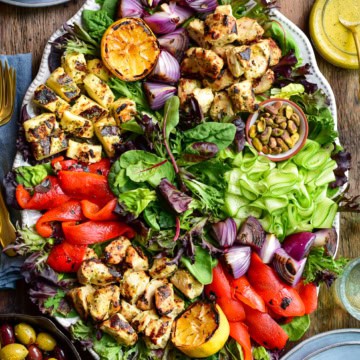 A grilled chicken and halloumi salad served with lemon dressing and olives.