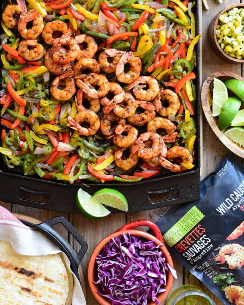 An Ooni Grizzler pan filled with shrimp fajitas.