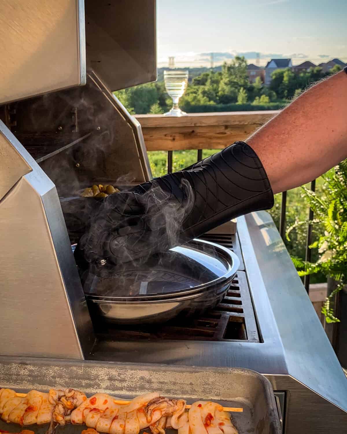 Closing the lid of a skillet to steam mussels.