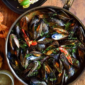 A skillet of Red Thai Curry Mussels.