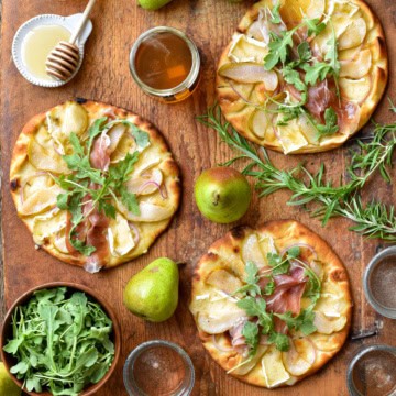 Three mini pear and prosciutto naan pizzas.