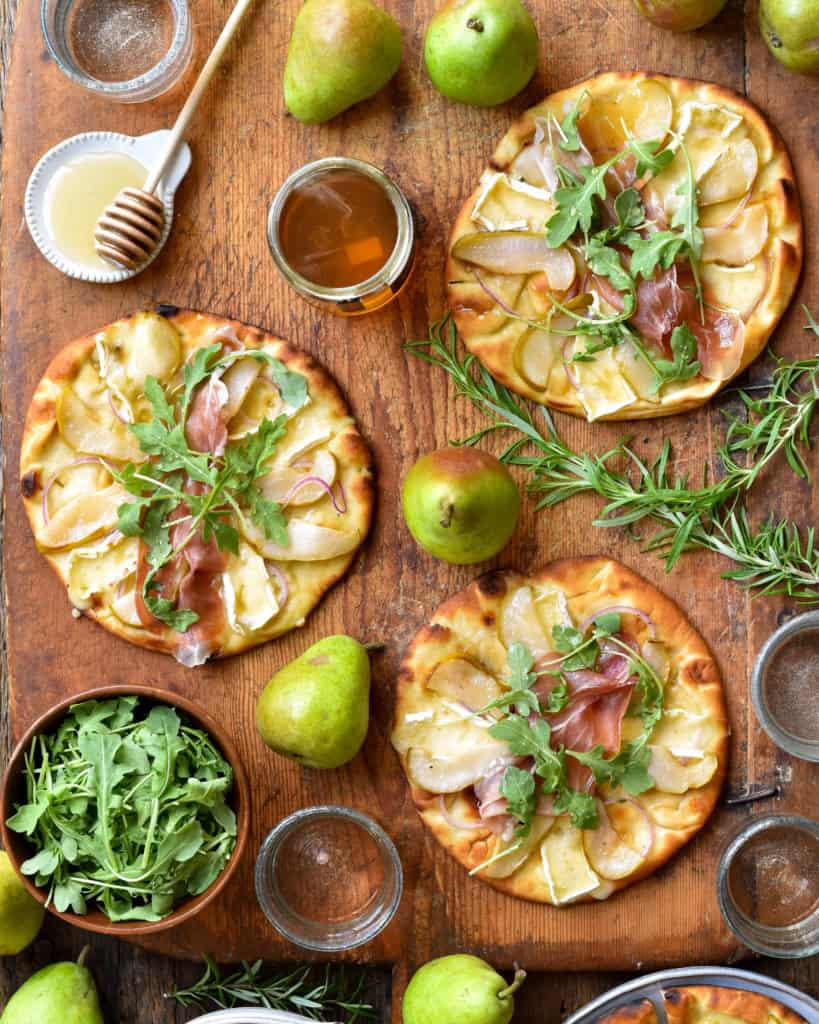 Three mini pear and prosciutto naan pizzas.