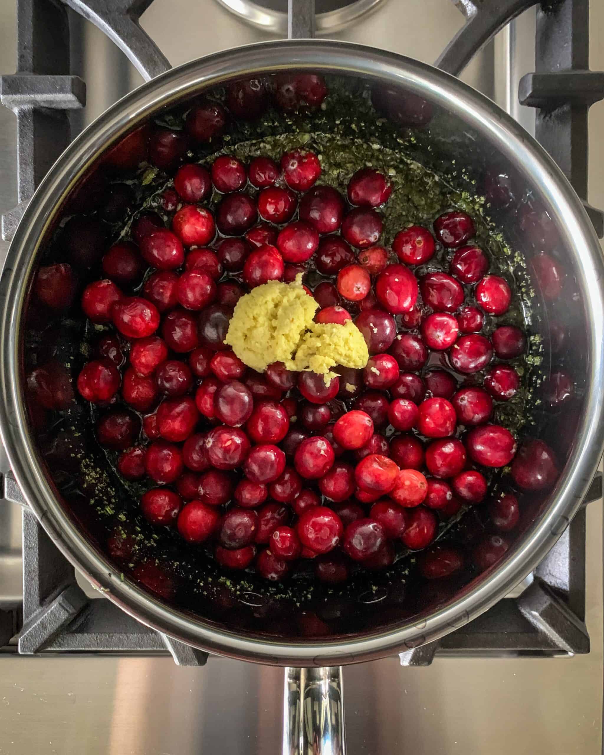 Ginger and cranberries are added into the pot.