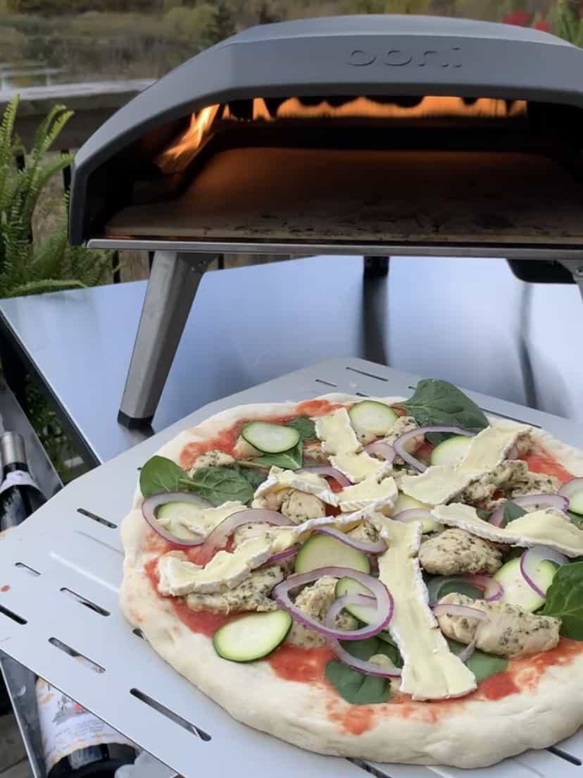 A pizza on a peel, ready to go into the preheated pizza oven.