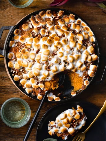 Wood-fired Sweet Potato Casserole in a cast iron skillet with a scoop taken out