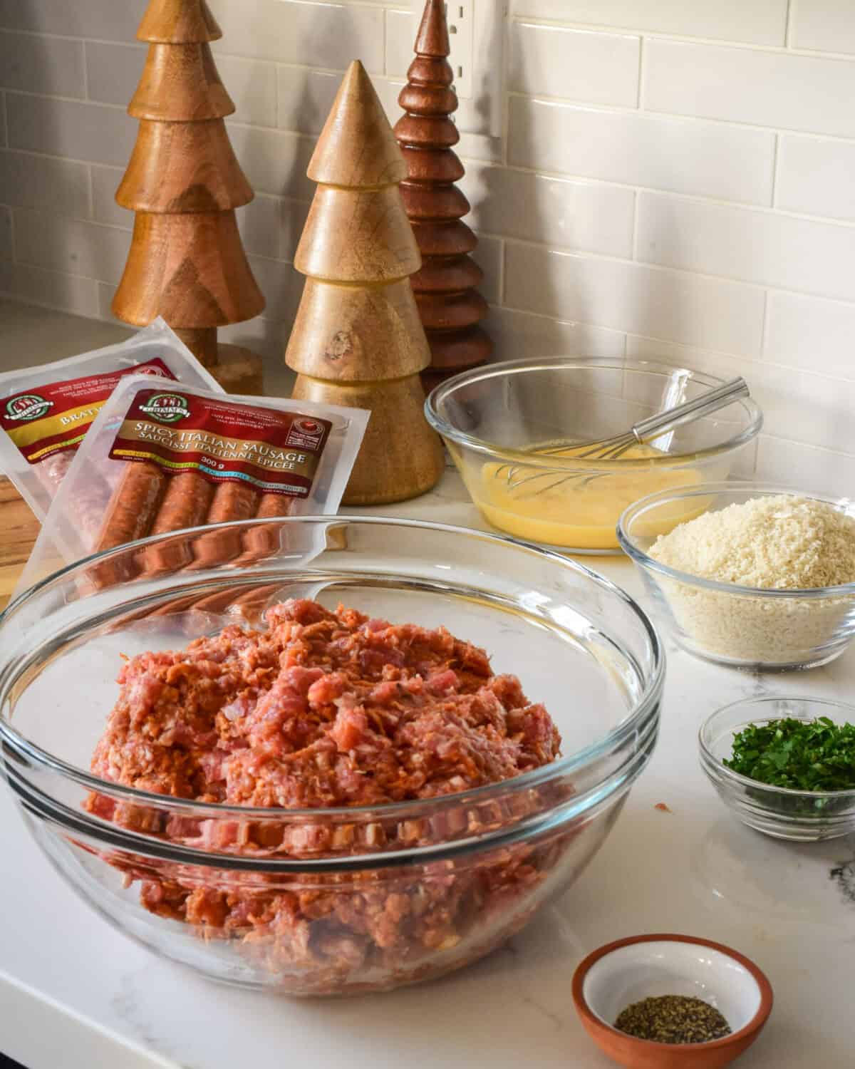 Bowls of ingredients for sausage meatballs.