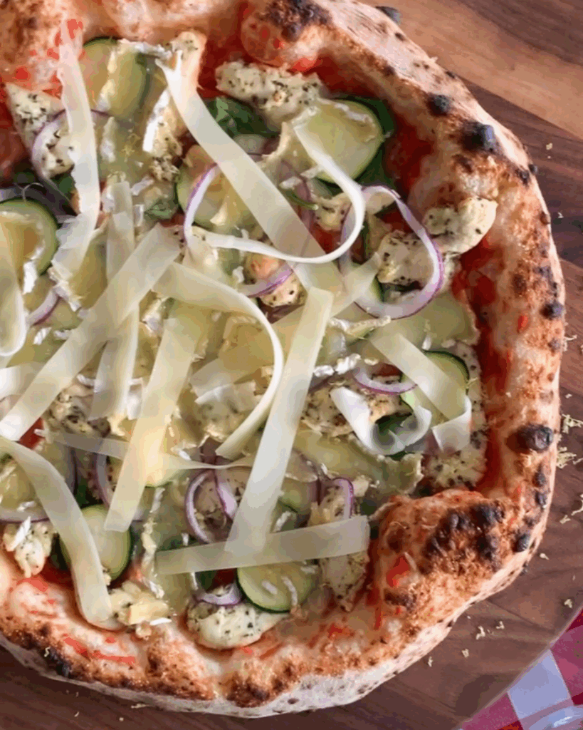A close up of a Lemon-Rosemary Chicken Pizza with cheese strips.