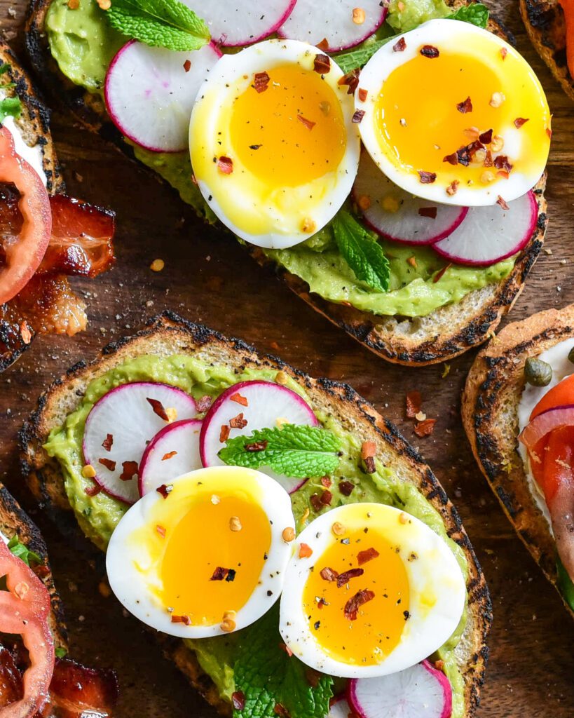 A close up image of guacamole toast with eggs.