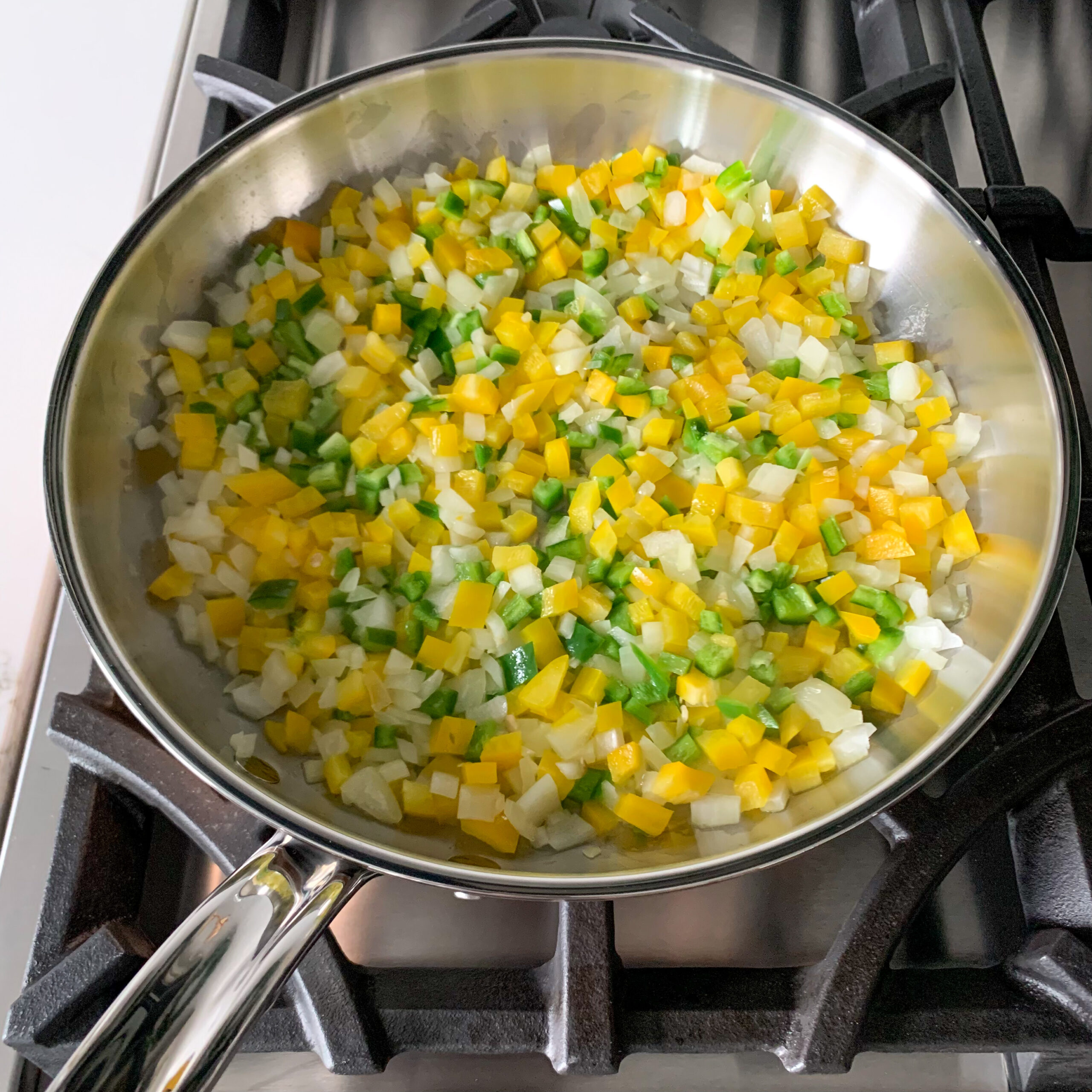 Start by cooking the onion, yellow pepper, and jalapeño to the preheated skillet.