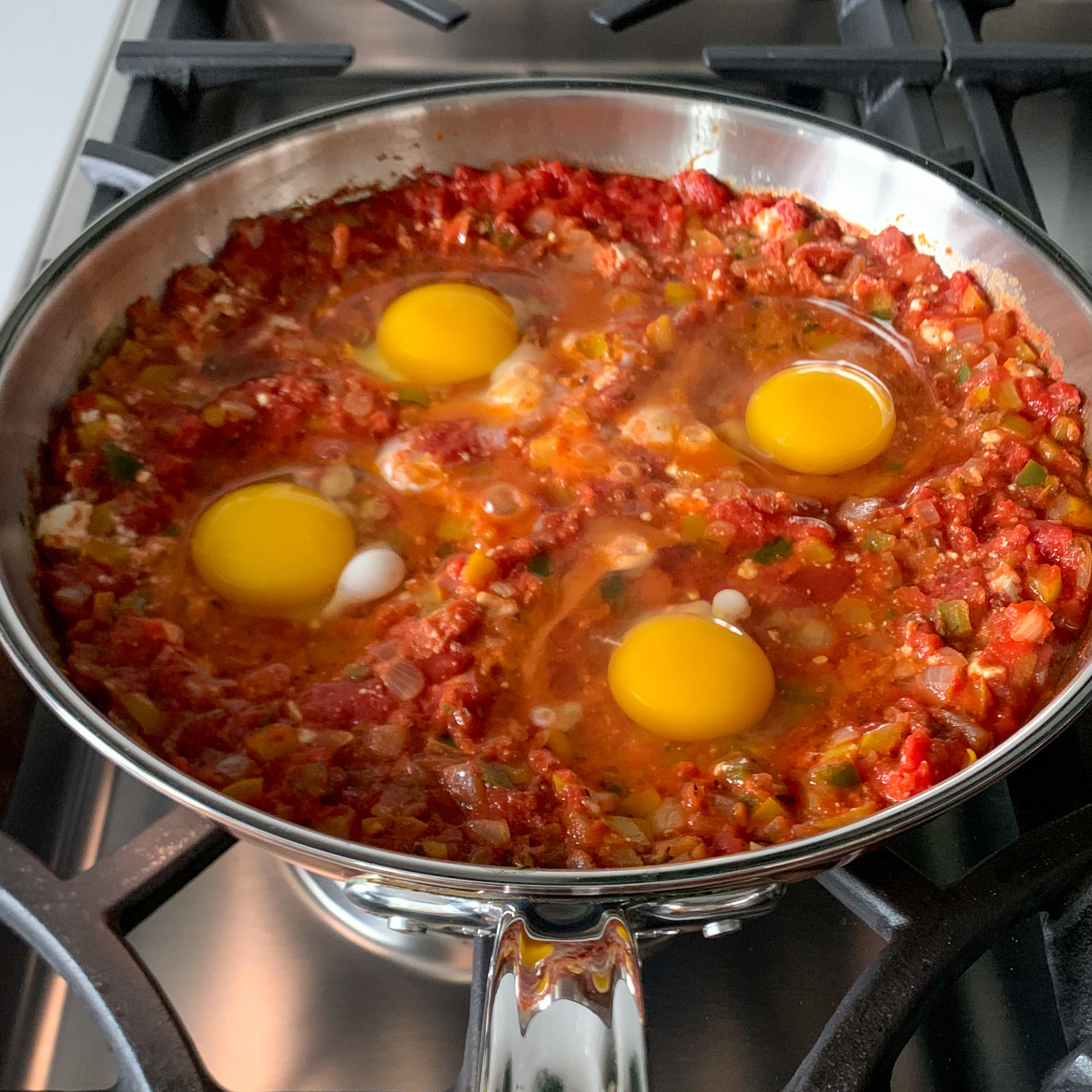 Cooking the eggs in the shakshuka