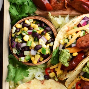 A bowl of Corn & Black Bean Salsa on a taco platter.