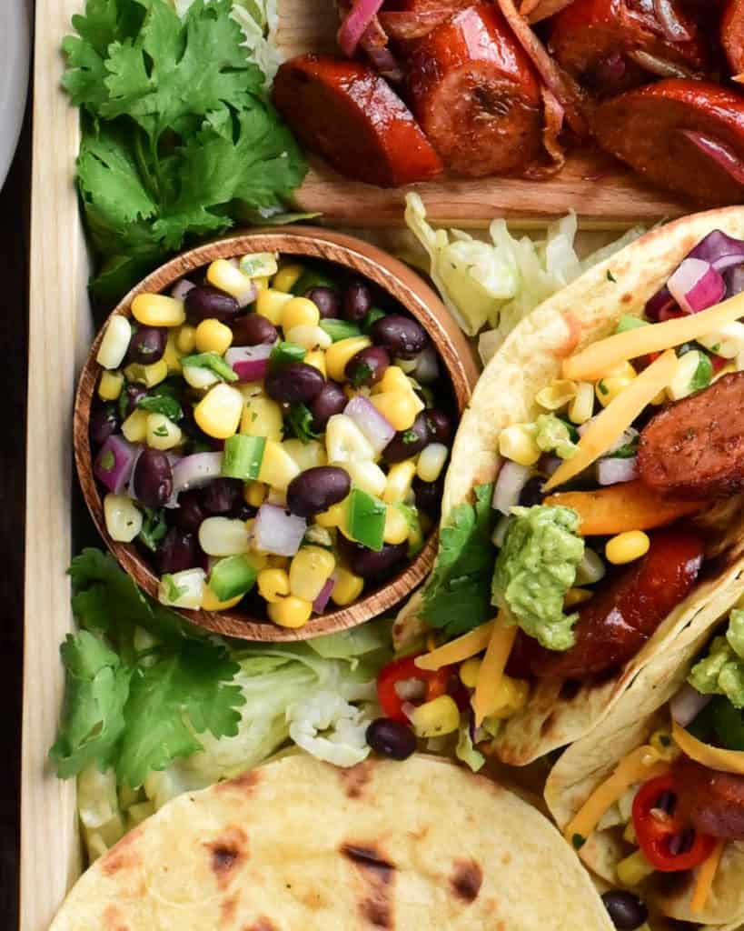 A bowl of Corn & Black Bean Salsa on a taco platter.
